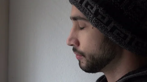 Thoughtful Man with a Cap Drinks Cup of Coffee near a Window, Close up Stock Footage 72099417
