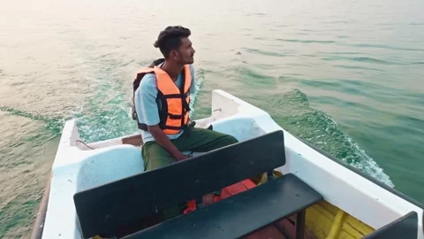 Thoughtful Man in life jacket steering a boat with scenic mountain and lake.. Stock Footage 263950570