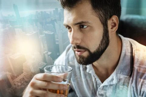 Thoughtful man looking into the distance while drinking alcohol Stock Photos