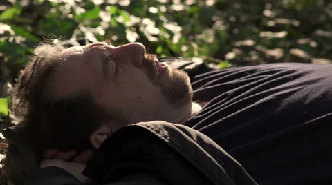 Thoughtful man lying on the ground in a forest: melancholy, loneliness, pensive Stock-Footage 62902796