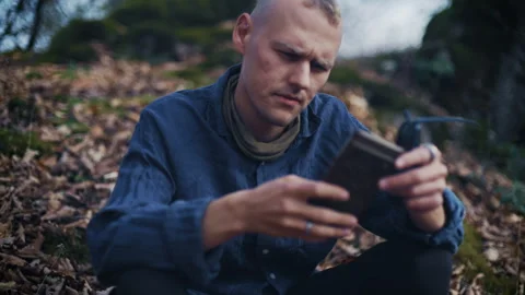 A thoughtful man in nature using a mobile phone device in nature Stock-Footage 302211263