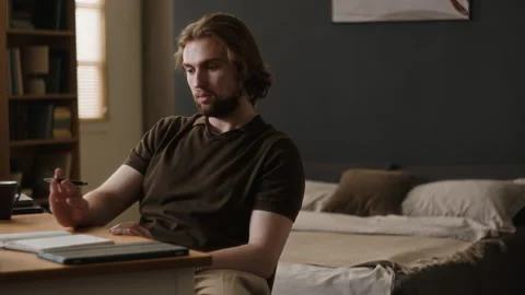 Thoughtful Man Sitting at Desk Thinking About Remote Work Stock Footage 345514368