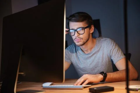 Thoughtful man thinking and working with computer in dark room Stock Photos
