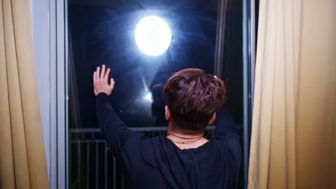 Thoughtful Man Touches Window Under Moonlight Glow Stock Footage 311149688