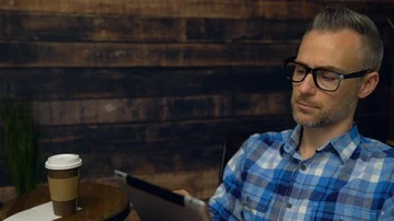 Thoughtful man using tablet in cafe Stock Footage 85523296