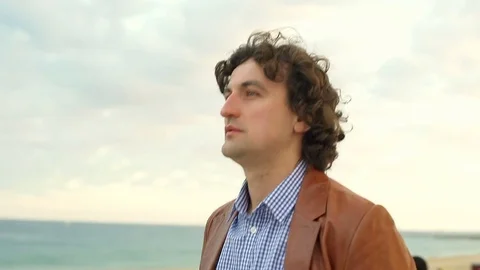 Thoughtful man walking on the beach and smiling, steadycam shot Видео 72857957