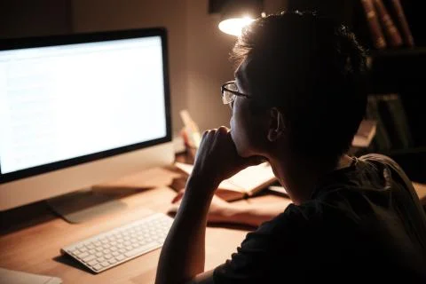 Thoughtful man working with blank screen computer in dark room Stock Photos
