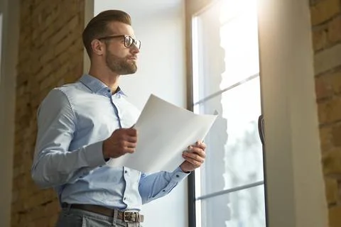 Thoughtful manager with documents at work alone Stock Photos