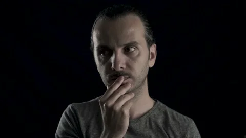 Thoughtful man's face portrait in studio, black background. Young handsome co Stock Footage 133414938