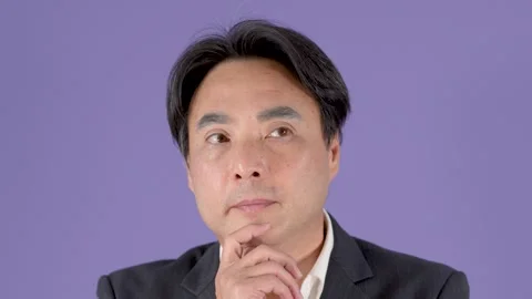 Thoughtful Middle Aged Businessman Posing Against Purple Studio Background Stock Footage 323497046