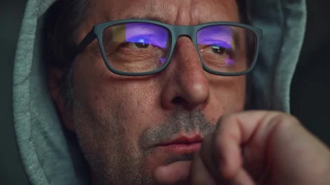 Thoughtful middle-aged man with glasses looking at computer screen, screen .. Stock Footage 313881217
