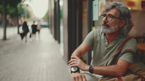 Thoughtful middle-aged man with gray hair and beard, wearing casual clothes, Stockbeeldmateriaal 227035704