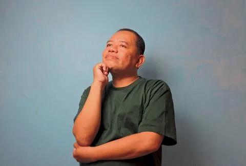 Thoughtful Middle-Aged Man Looking Up with Hand on Chin Stock Photos