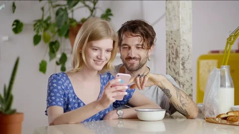 Thoughtful nice couple scrolling with finger new application using pink gadget Stock Footage 108797361