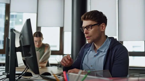 Thoughtful office manager typing computer. Focused software engineer programming Stock Footage 242981073