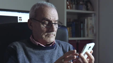Thoughtful old man is using smartphone with touchscreen Stock Footage 47826525