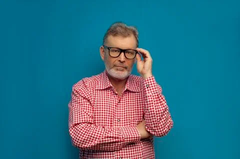 Thoughtful old man wearing smart casual shirt and stylish glasses Stock Photos
