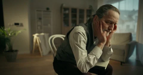 Thoughtful older man sitting on the floor in a calm living room Stock Footage 336278764