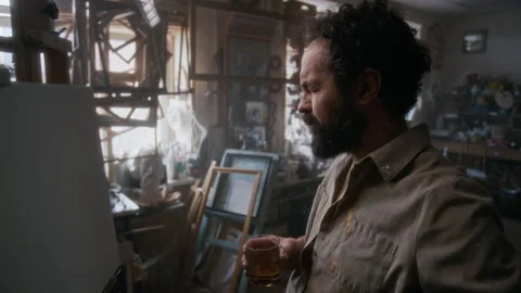 Thoughtful Painter Drinking Whiskey while Creating Artwork in Studio Stock Footage 334681892