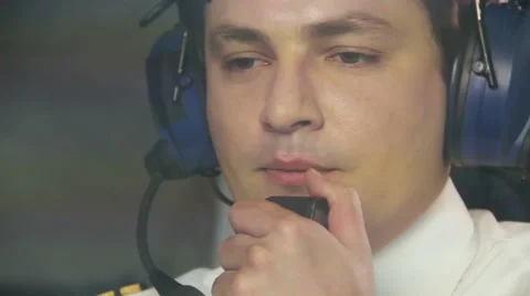 Thoughtful pilot talking to dispatcher over radio set and navigating plane Stock Footage 64602860