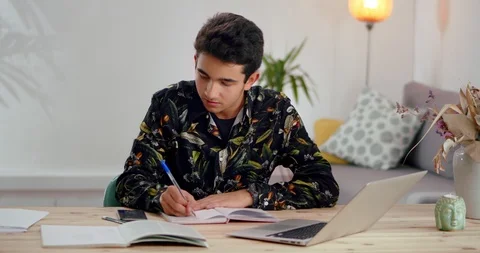 Thoughtful pupil guy studying alone at home school subject to get ready for Stock Footage 120946695