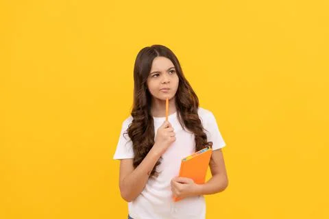 Thoughtful school child ready to study with workbook and pen, school Stock Photos