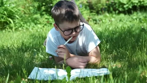 Thoughtful schoolboy in eyeglasses thinking of solution, idea. child boy doin Stock Footage 136674199