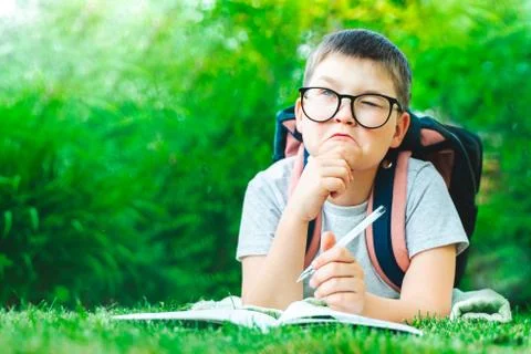 Thoughtful schoolboy in glasses thinking of solution, idea. dreamy child boy  Stock Photos