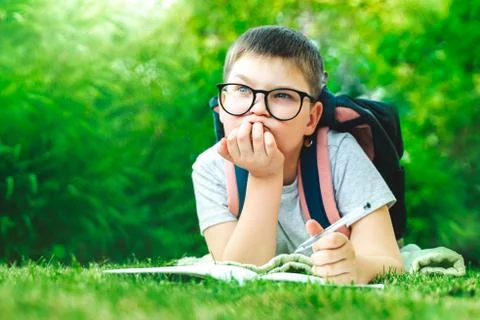 Thoughtful schoolboy in glasses thinking of solution, idea. dreamy child boy  Stock Photos