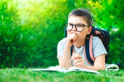 Thoughtful schoolboy in glasses thinking of solution, idea. dreamy child boy  Stock Photos