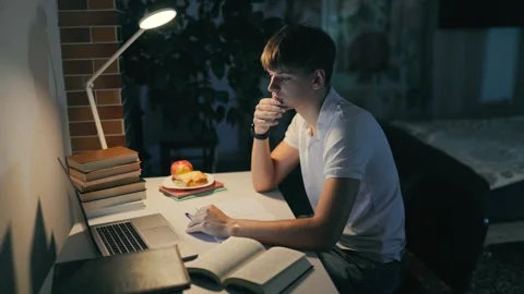 Thoughtful schoolboy looking at the laptop during night home study. Stock Footage 345211033