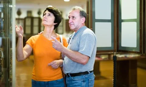 Thoughtful senior couple examining objects applied art in museum Fotos Stock