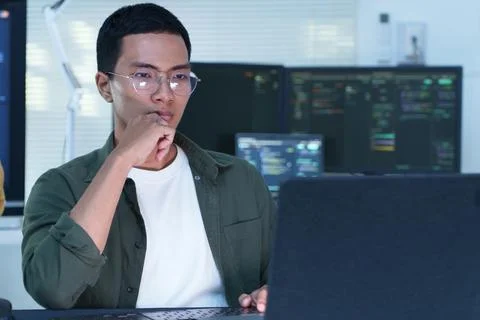Thoughtful Software Developer Working with Code on Laptop Stock Photos