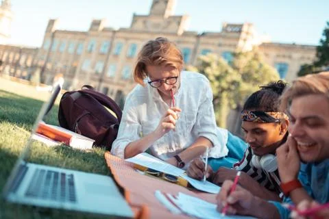 Thoughtful student solving maths problem with his friends. Stock Photos