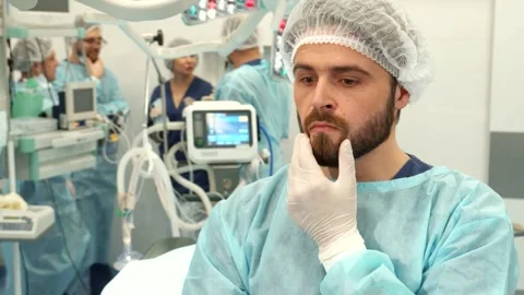 Thoughtful surgeon contemplating in the operating room Stock Footage 311990926