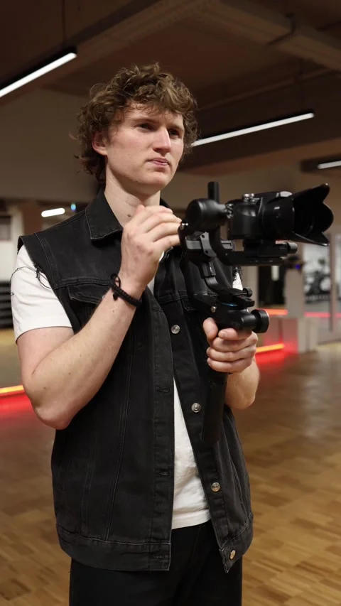 Thoughtful videographer adjusting camera Video stock 332116700
