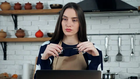 Thoughtful woman in apron thinks solution problem holiday restaurant food menu Stock Footage 148092181