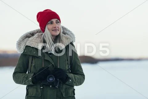 Thoughtful Woman With Camera Enjoying Winter Season