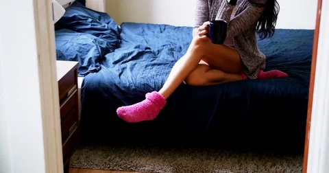 Thoughtful woman having coffee on bed Stock Footage