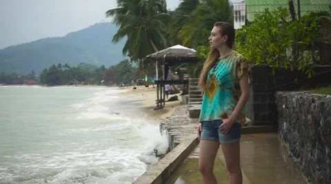 Thoughtful Woman Standing on the Coast on the Background of Crashing Waves. Slow Stock Footage 59794159