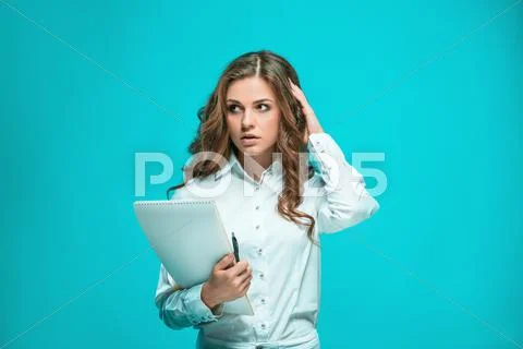The thoughtful young business woman with pen and tablet for notes on blue Stock Photos