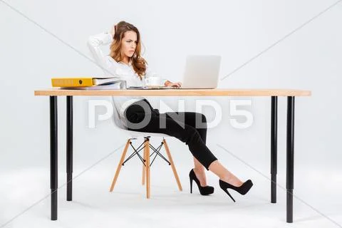 Thoughtful young businesswoman thinking and working with laptop Stock Photos