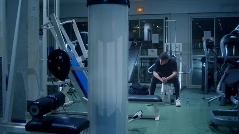 Thoughtful young male alone in the gym Stock Footage