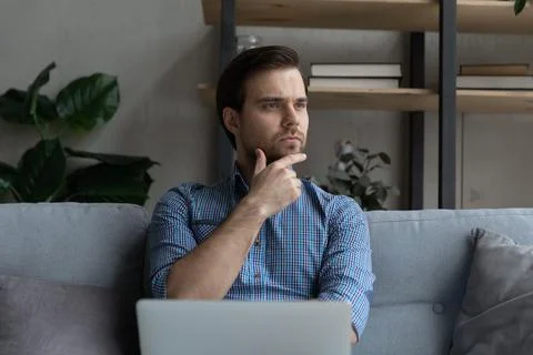 Thoughtful young man considering problem solution at home. 스톡 사진