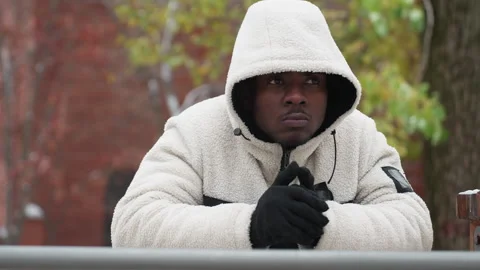 Thoughtful Young Man Cracks Knuckles Resting on Iron Bar in Winter City Scene Stock Footage 305628562