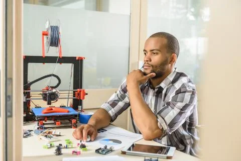 Thoughtful young man engineering 3d printer Stock Photos