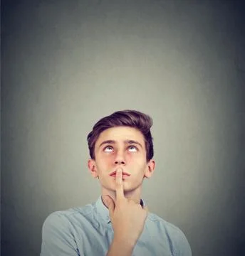 Thoughtful young man looking up Stock Photos