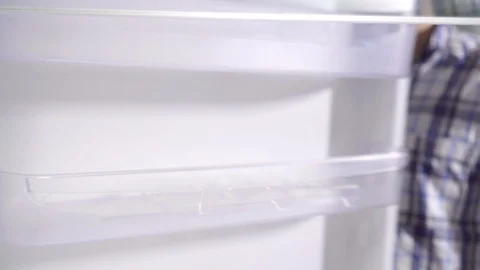 Thoughtful young man looks into the empty fridge Stock Footage 119761633