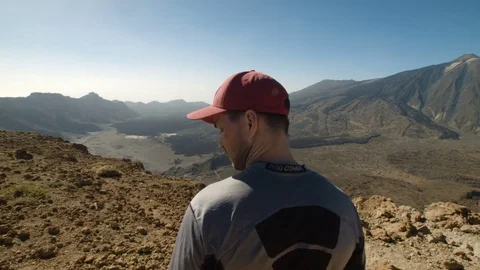 Thoughtful Young Man on the Mountain Looking Around Stock Footage 77567147
