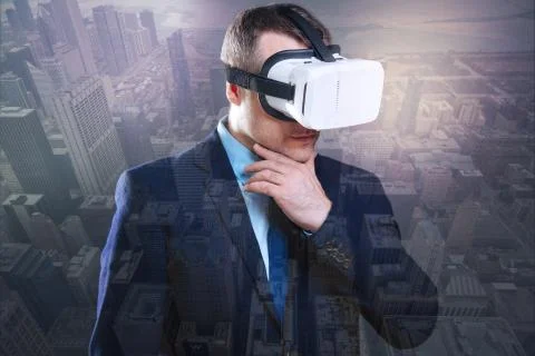 Thoughtful young man trying virtual reality glasses Foto stock